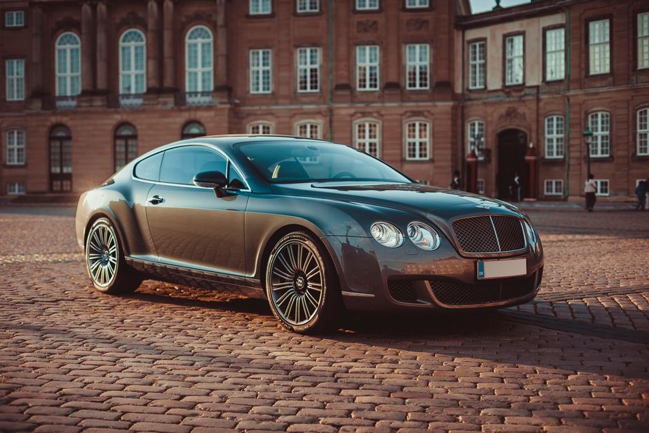 Elegant Bentley Continental GT on cobblestone street in historic Copenhagen during daytime